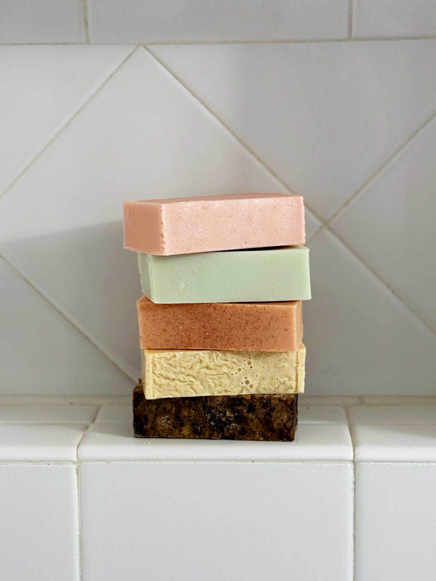 African black soap and sake kasu soap - lifestyle stacked in shower | OM Botanical