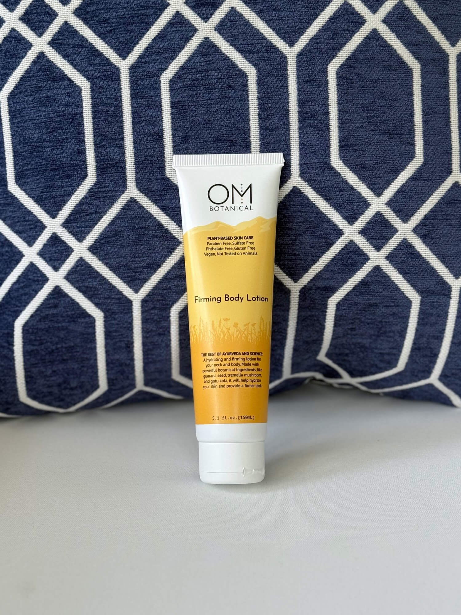 Firming Body Lotion - lifestyle on a couch scene | OM Botanical