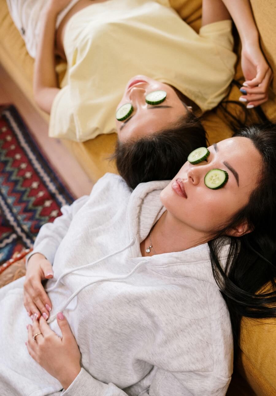 Women enjoying natural skin care wellness regimen with cucumber slices