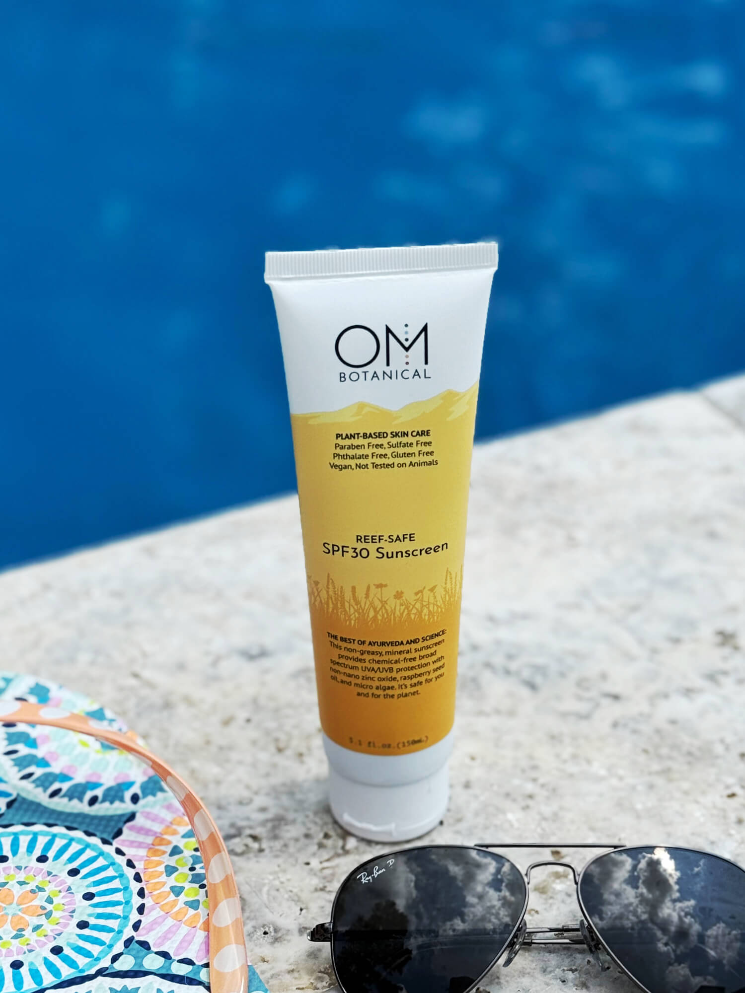 Reef safe spf30 sunscreen - lifestyle in the sun next to pool | OM Botanical